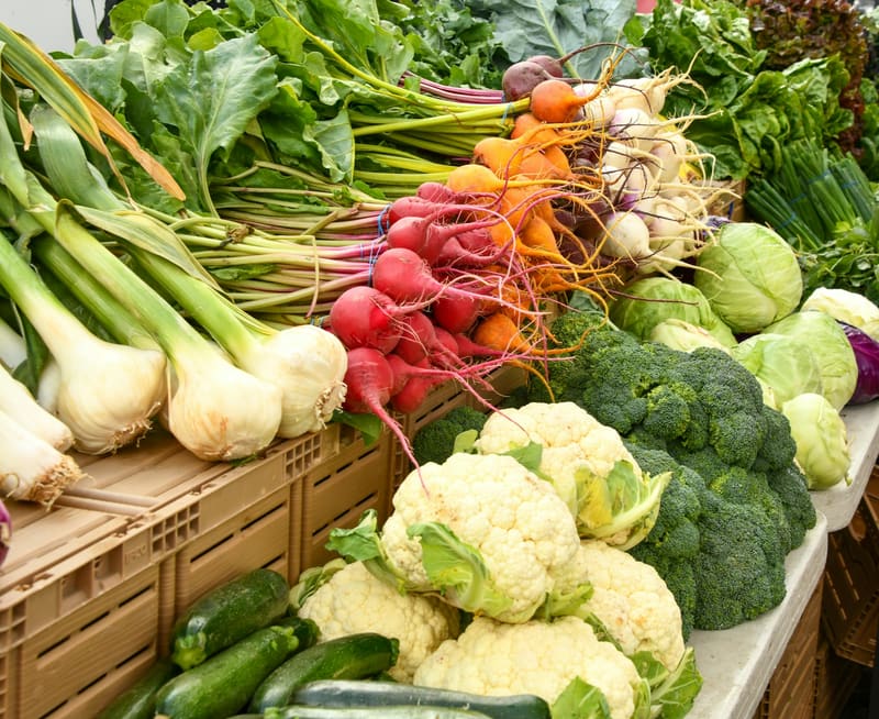 Marktstand mit frischem Blumenkohl, Brokkoli, Radieschen und Zwiebeln